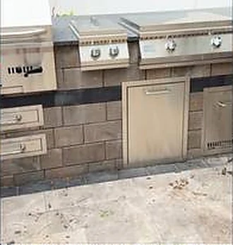Outdoor kitchen run with two built-in grills, drawers and an access door